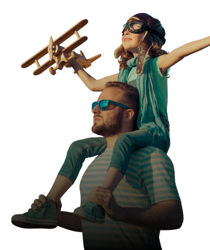 Child wearing aviator goggles holding a toy plane on father’s shoulders, symbolizing imagination and freedom